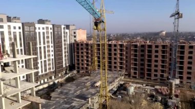 Yüksek binaların inşaatı ve inşaatı, çalışma ekipmanları ve işçileri olan inşaat endüstrisi. Yukarıdan bak, yukarıdan. Arkaplan ve doku