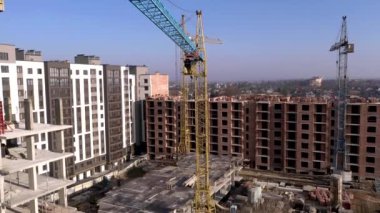 Yüksek binaların inşaatı ve inşaatı, çalışma ekipmanları ve işçileri olan inşaat endüstrisi. Yukarıdan bak, yukarıdan. Arkaplan ve doku