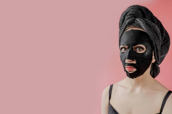 Ung Kvinna Tillämpa Svart Kosmetisk Tyg Ansiktsmask Rosa Bakgrund Ansikte — Stockfoto