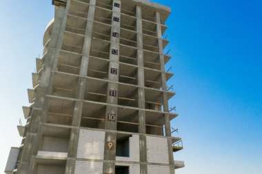 Bir şehirde inşaat halindeki yüksek apartmanın beton çerçevesinin havadan görünüşü.