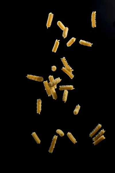 Falling Fusilli Pasta Flying Yellow Raw Macaroni Black Background — Stock Photo, Image