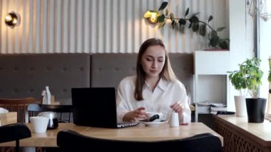 Kahve molasında kahve içen genç bir iş kadını. Tablet bilgisayarı kullanılıyor