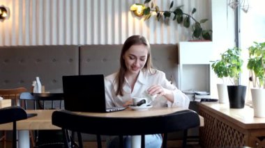 Kahve molasında kahve içen genç bir iş kadını. Tablet bilgisayarı kullanılıyor