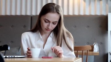 Kahve molasında kahve içen genç bir iş kadını. Tablet bilgisayarı kullanılıyor