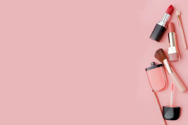 Scrivania donna con cosmetici decorativi per il trucco su sfondo rosa spazio piatto laici per il testo — Foto Stock
