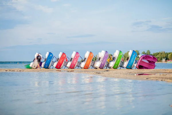 Ułożone katamarany na jeziorze. Jasne kolorowe rowery wodne na plaży nad jeziorem — Zdjęcie stockowe