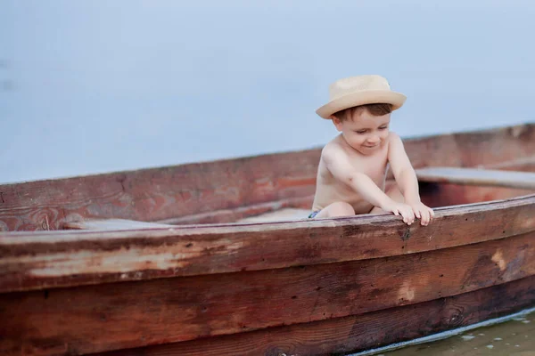 小男孩正在湖上的一条船上休息 — 图库照片