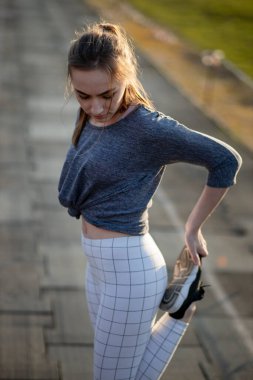 Koşucu kadın koşucu koşu yolunda bacaklarını açıyor.