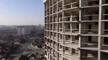 Bir şehirde inşaat halindeki yüksek apartmanın beton çerçevesinin havadan görünüşü