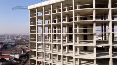 Bir şehirde inşaat halindeki yüksek apartmanın beton çerçevesinin havadan görünüşü