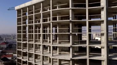Bir şehirde inşaat halindeki yüksek apartmanın beton çerçevesinin havadan görünüşü