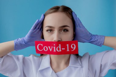 Doktor kadın mavi arka planda kurtarılmış Coronavirüs olan kırmızı kağıda işaret ediyor. Dünya Sağlık Örgütü WHO, COVID-19 adlı Coronavirus hastalığına yeni bir resmi isim verdi.