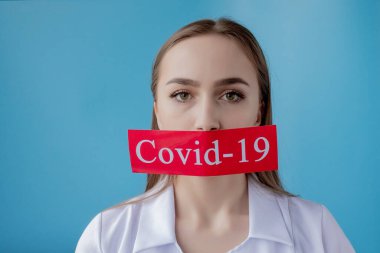 Doktor kadın mavi arka planda kurtarılmış Coronavirüs olan kırmızı kağıda işaret ediyor. Dünya Sağlık Örgütü WHO, COVID-19 adlı Coronavirus hastalığına yeni bir resmi isim verdi.