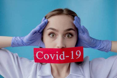 Doktor kadın mavi arka planda kurtarılmış Coronavirüs olan kırmızı kağıda işaret ediyor. Dünya Sağlık Örgütü WHO, COVID-19 adlı Coronavirus hastalığına yeni bir resmi isim verdi.