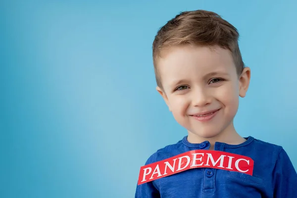 Niño Apuntando Papel Rojo Con Mesaage Pandemia Sobre Fondo Azul —  Fotos de Stock