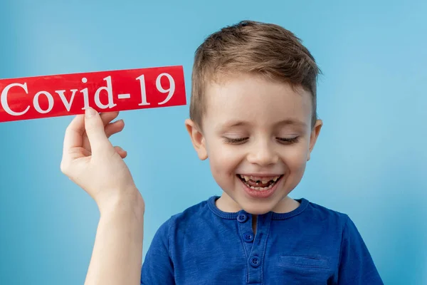 Niño Apuntando Papel Rojo Con Mesaage Coronavirus Sobre Fondo Azul —  Fotos de Stock