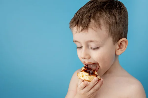 Mały Chłopiec Jedzący Pączkową Czekoladę Niebieskim Tle Słodki Szczęśliwy Chłopiec — Zdjęcie stockowe
