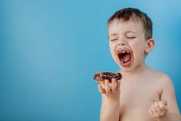 Kleiner Junge Isst Donut Schokolade Auf Blauem Hintergrund Niedlichen Glücklichen — Stockfoto