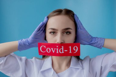Doktor kadın mavi arka planda kurtarılmış Coronavirüs olan kırmızı kağıda işaret ediyor. Dünya Sağlık Örgütü WHO, COVID-19 adlı Coronavirus hastalığına yeni bir resmi isim verdi.
