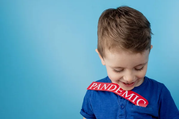 Niño Apuntando Papel Rojo Con Mesaage Pandemia Sobre Fondo Azul —  Fotos de Stock