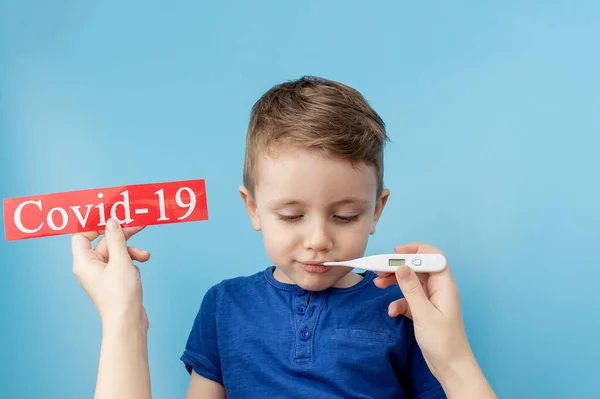 Niño Apuntando Papel Rojo Con Mesaage Coronavirus Sobre Fondo Azul —  Fotos de Stock