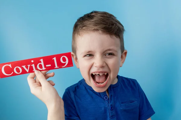 Ragazzino Che Indica Carta Rossa Con Mesaage Coronavirus Sfondo Blu — Foto Stock