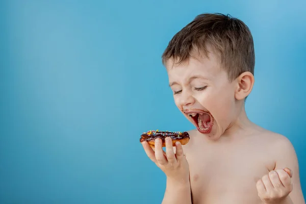 Kleine Jongen Die Donut Chocolade Eet Een Blauwe Achtergrond Leuke — Stockfoto