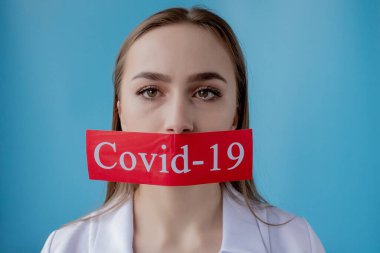 Doktor kadın mavi arka planda kurtarılmış Coronavirüs olan kırmızı kağıda işaret ediyor. Dünya Sağlık Örgütü WHO, COVID-19 adlı Coronavirus hastalığına yeni bir resmi isim verdi.