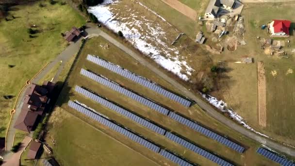 緑の芝生の背景に再生可能エネルギーを生成する太陽光発電パネルシステムの大規模なフィールドの空中ビュー — ストック動画