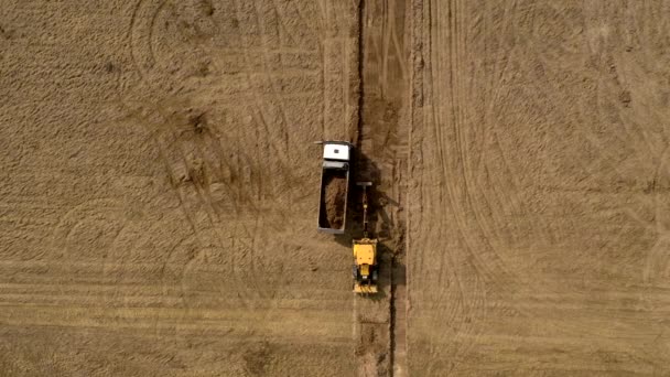 ローダーショベルは 道路建設でトラックに地面をロードします — ストック動画
