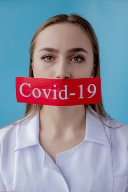 Doktor kadın mavi arka planda kurtarılmış Coronavirüs olan kırmızı kağıda işaret ediyor. Dünya Sağlık Örgütü WHO, COVID-19 adlı Coronavirus hastalığına yeni bir resmi isim verdi