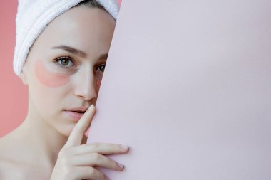 Pembe arka planda göz bantları olan güzel kadın portresi. Göz Altında Maskeli Kadın Güzellik Yüzü. Cilt bakımı, fotokopi alanı ile kozmetik ürün kavramı.