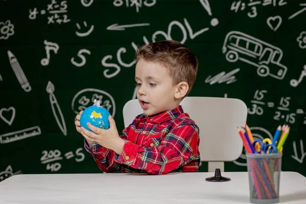 Portret Uroczego Chłopca Trzymającego Dłoniach Mały Globus Tle Tablicy Gotowy — Zdjęcie stockowe