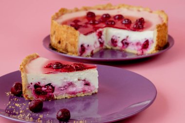 Nane yaprağıyla süslenmiş yaban mersini soslu sade cheesecake dilimi. Yakın görünüm.