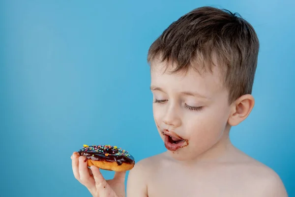 Ragazzino Che Mangia Cioccolato Ciambella Sfondo Blu Carino Ragazzo Felice — Foto Stock