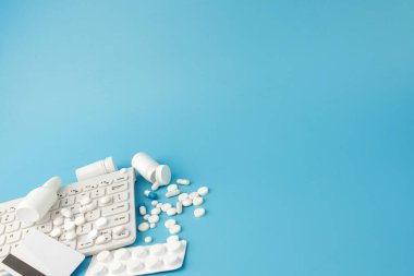 İlaç ve klavyeli alışveriş arabası oyuncağı. Haplar, su toplayan paketler, tıbbi şişeler, termometre, mavi arka planda koruyucu maske. - Evet. Sağlık ve internet alışverişi. Metniniz için en üstteki görünüm.