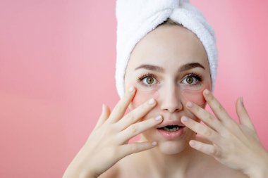 Pembe arka planda göz bantları olan güzel kadın portresi. Göz Altında Maskeli Kadın Güzellik Yüzü. Cilt bakımı, kozmetik ürün konsepti.