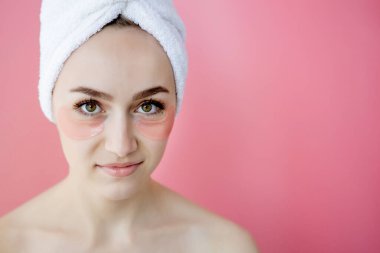 Pembe arka planda göz bantları olan güzel kadın portresi. Göz Altında Maskeli Kadın Güzellik Yüzü. Cilt bakımı, fotokopi alanı ile kozmetik ürün kavramı.