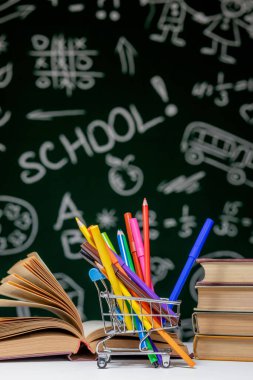 Kitap, kalem ve küre ile okul arka planına yeşil karatahta arka planında beyaz masa üzerinde