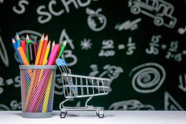 Kitap, kalem ve küre ile okul arka planına yeşil karatahta arka planında beyaz masa üzerinde