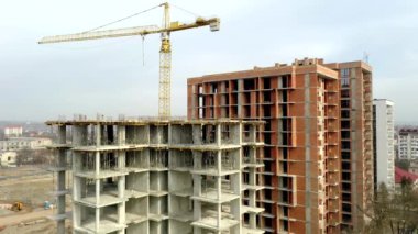 Bir şehirde inşaat halindeki yüksek apartmanın beton çerçevesinin havadan görünüşü