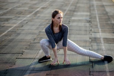 Koşucu kadın koşucu koşu yolunda bacaklarını açıyor.