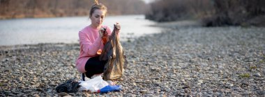 Genç bayan gönüllü nehirde çöp topluyor..