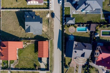 Beton zeminli yeşil çimenli asfalt bahçeli özel bir evin havadan görünüşü.