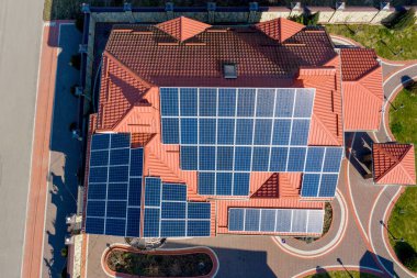 Mavi panelli, yeni, modern bir ev kulübesinin havadan görünüşü. Yenilenebilir ekolojik yeşil enerji üretim kavramı.