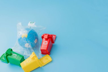 Sarı, yeşil ve kırmızı geri dönüşüm kutularında mavi arka planda geri dönüşüm sembolü var. Şehri düzenli tutar, geri dönüşüm sembolünü bırakır. Doğa koruma kavramı.