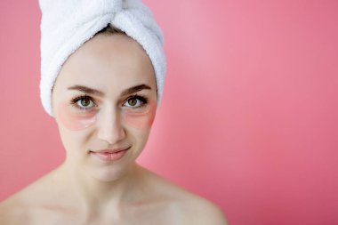 Pembe arka planda göz bantları olan güzel kadın portresi. Göz Altında Maskeli Kadın Güzellik Yüzü. Cilt bakımı, fotokopi alanı ile kozmetik ürün kavramı.