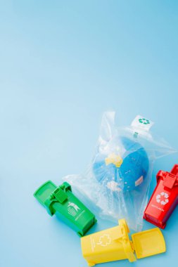 Sarı, yeşil ve kırmızı geri dönüşüm kutularında mavi arka planda geri dönüşüm sembolü var. Şehri düzenli tutar, geri dönüşüm sembolünü bırakır. Doğa koruma kavramı.