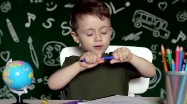 Ev ödevi yapan sevimli çocuk. Masada çizim yapan zeki bir çocuk. Öğrenci çocuk. İlkokul öğrencisi iş yerinde resim çiziyor. Çocuk öğrenmeyi seviyor. Evde eğitim. Okula dönelim. Okuldaki küçük çocuk..