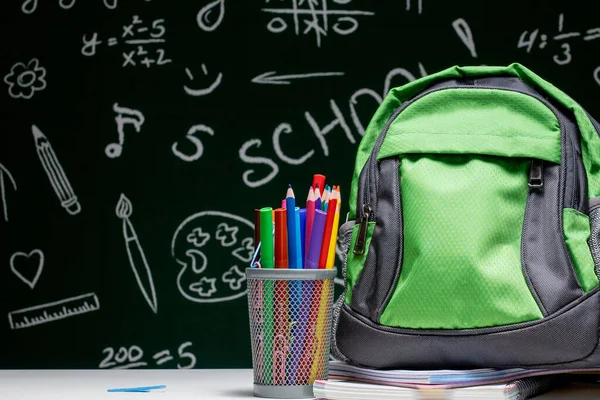 Bildungskonzept Grüner Rucksack Hefte Und Schulmaterial Auf Dem Hintergrund Der — Stockfoto